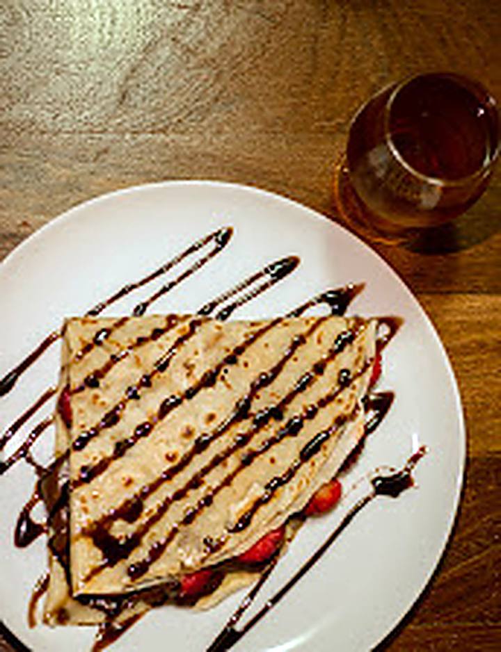 Crepe doce com calda de chocolate e morango